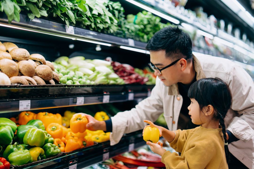 Father and child grocery shopping in the produce aisle