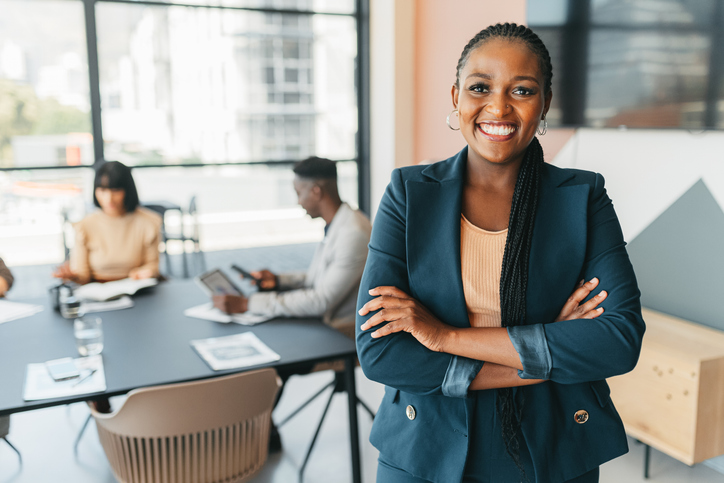 Smiling manager with small business employees in background