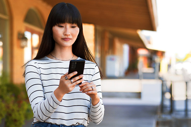 Woman standing outside checking her phone