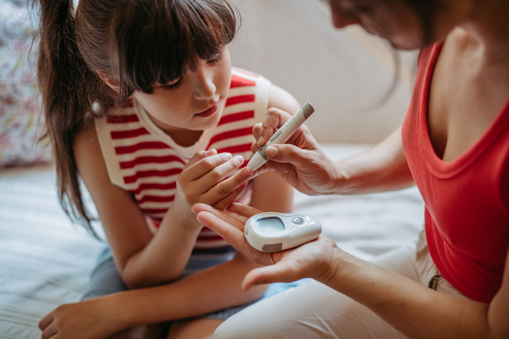 Parent pricking child's finger